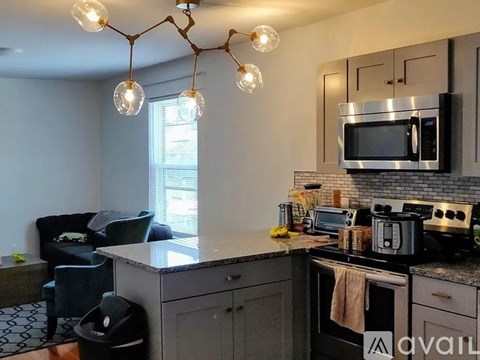 A kitchen with a black stove top oven and a microwave above it.