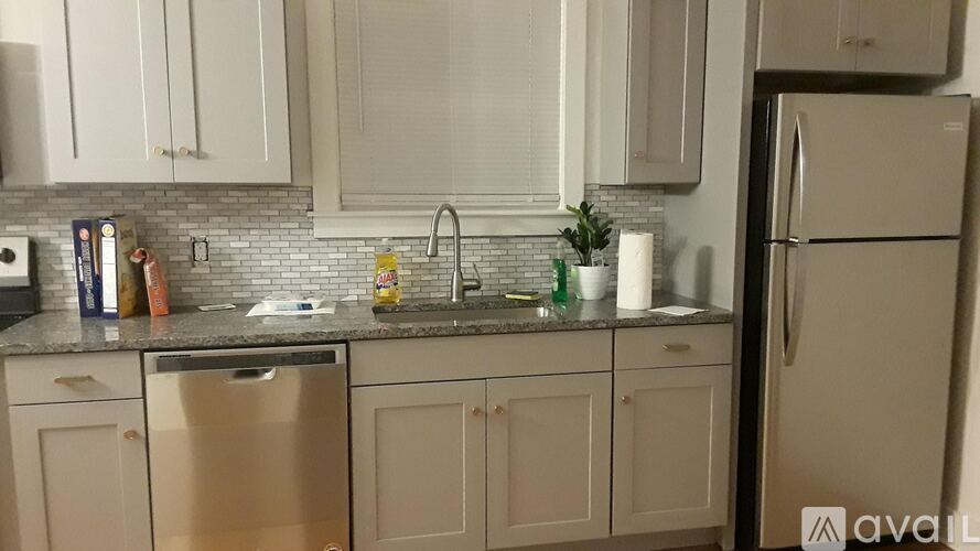 A kitchen with white cabinets and a granite countertop.
