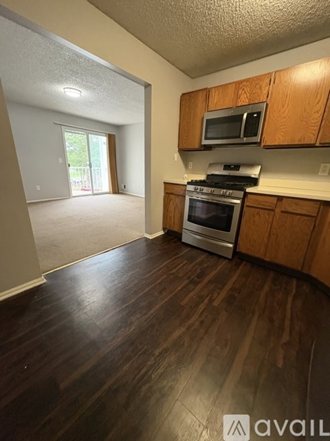 A kitchen with wooden cabinets and a stainless steel oven.
