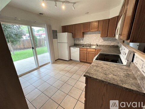 A kitchen with a white fridge and wooden cabinets.