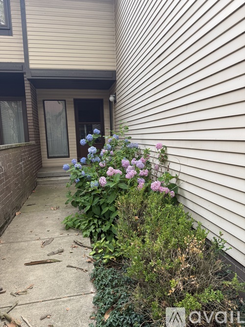 A house with a flower bed in front of it.
