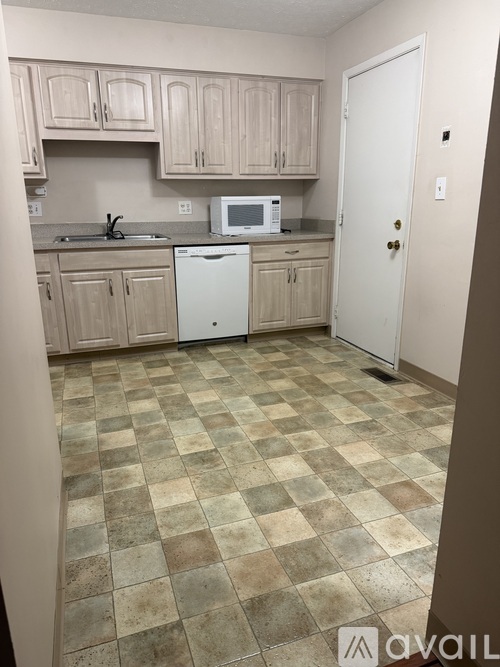 A kitchen with a checkered floor and a white refrigerator.