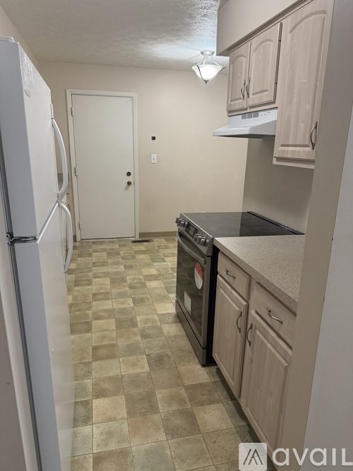 A kitchen with a checkered floor and a white fridge.