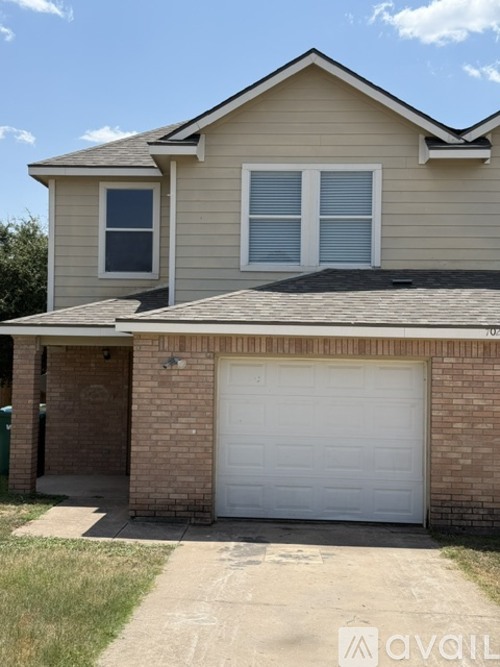 A two-story house with a garage door.