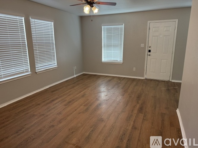 A room with wooden flooring and a ceiling fan.