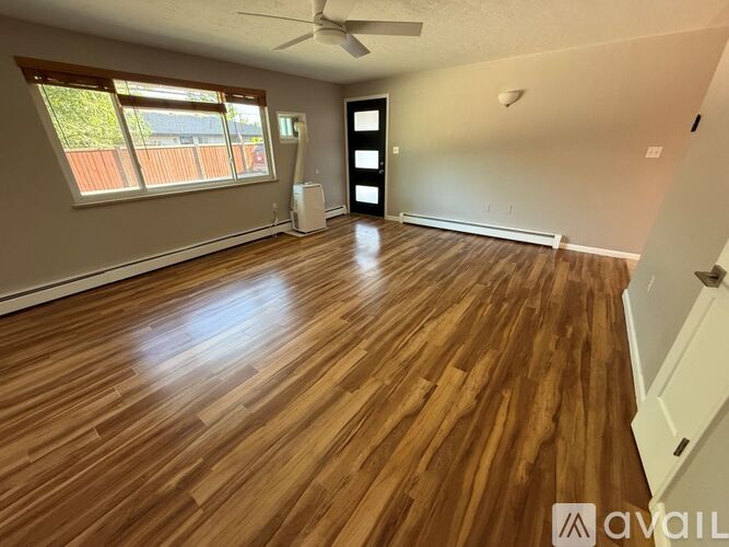 A room with wooden flooring and a ceiling fan.