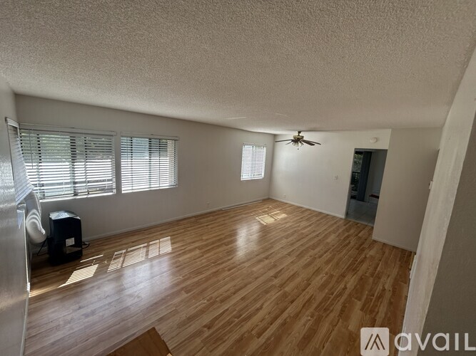 A room with wooden flooring and a ceiling fan.
