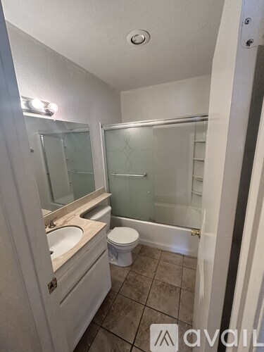A bathroom with a toilet, sink, and shower.