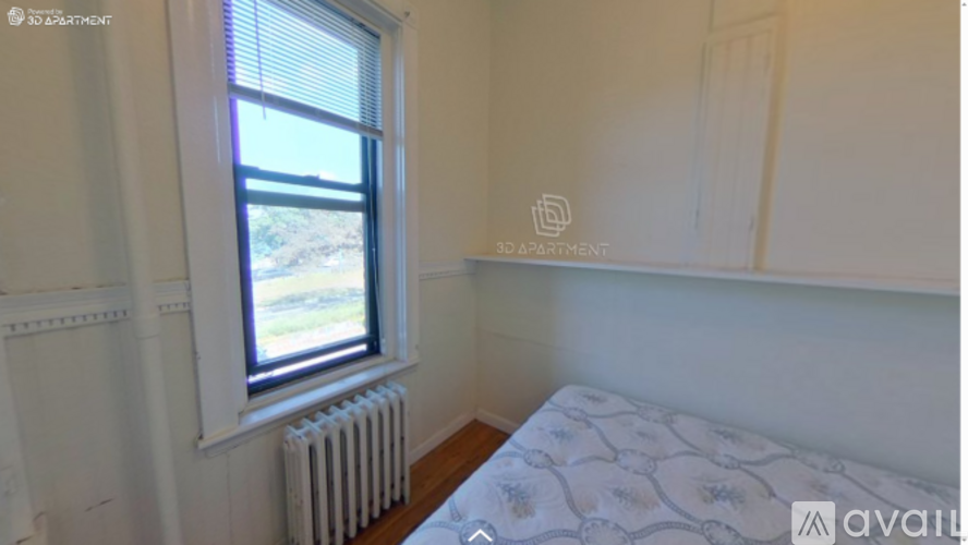 A bedroom with a window and a bed with a floral pattern.
