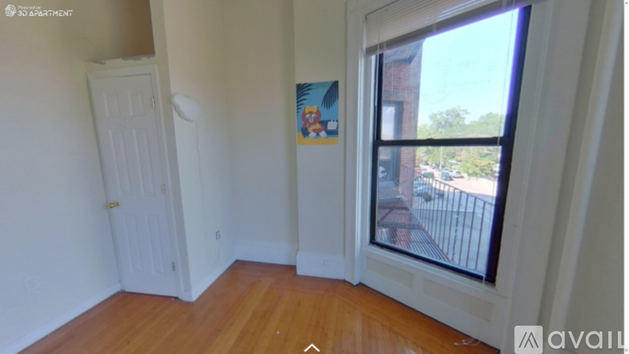 A room with a door and a window overlooking a balcony.
