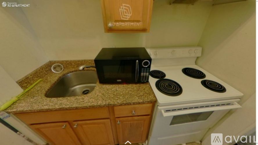 A kitchen with a stove, sink, and cabinets.