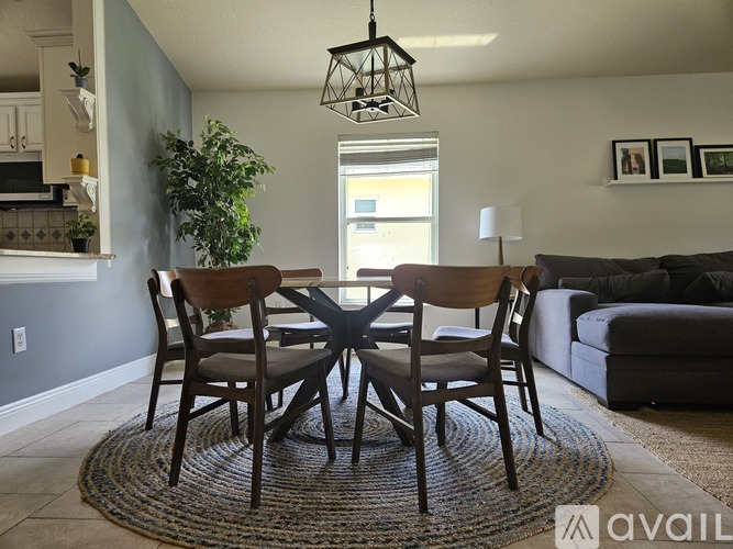 A dining room with a table and chairs.