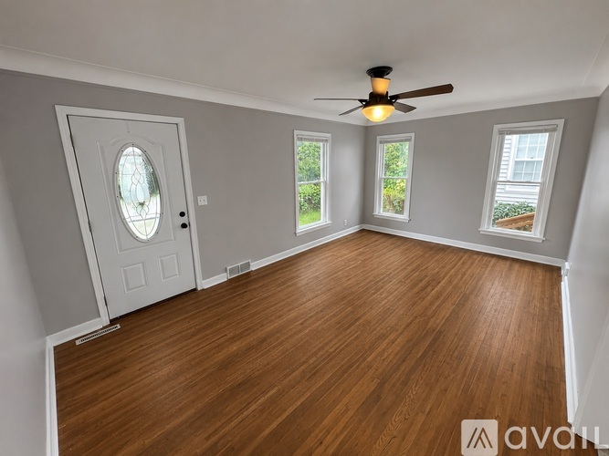 A room with wooden flooring and a ceiling fan.