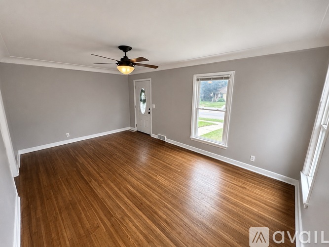 A room with wooden flooring and a ceiling fan.