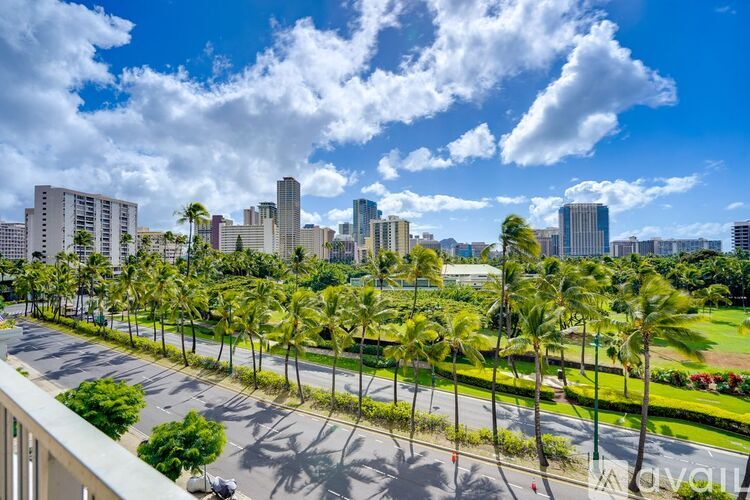 A cityscape with palm trees in the foreground.