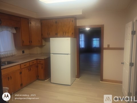 A kitchen with wooden cabinets and a white refrigerator.