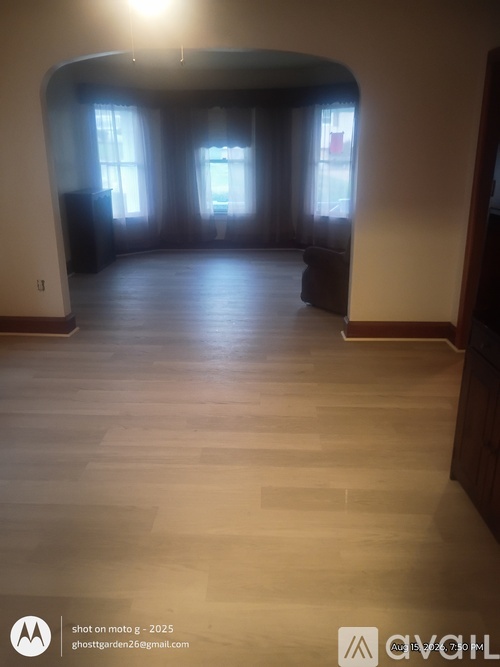 A room with wooden floors and a large arched doorway.
