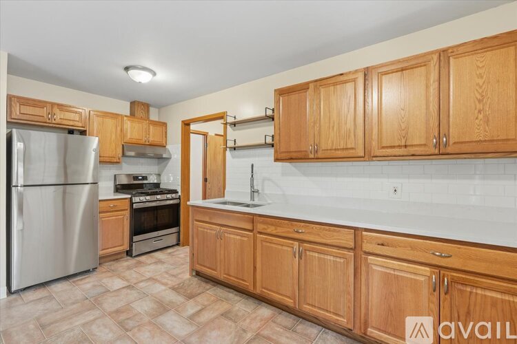 A kitchen with wooden cabinets and a tiled floor.