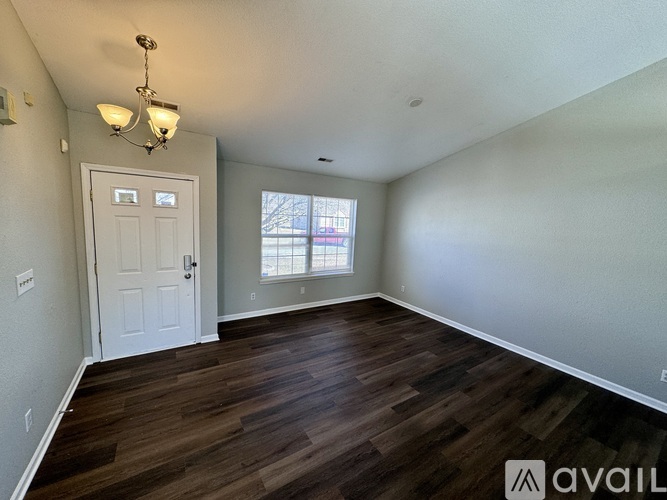 A room with wooden flooring and a white door.