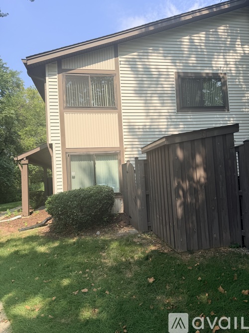 A house with a brown fence and a green lawn.