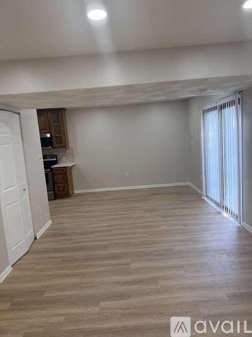 A room with wooden flooring and a window with blinds.