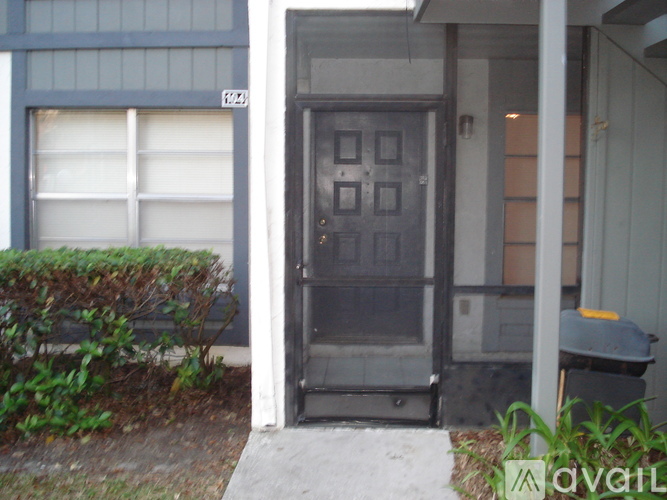 A grey door is in front of a grey building.