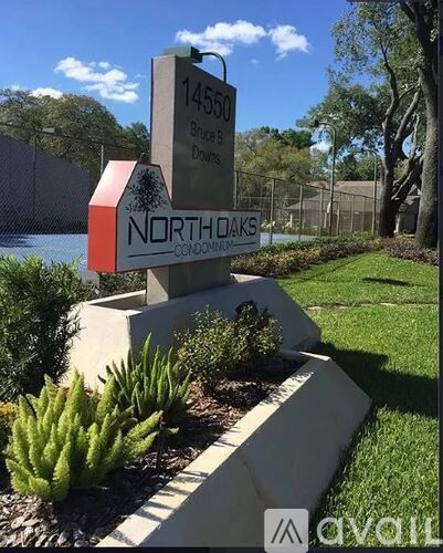 A sign for NorthOaks Condominiums stands in a landscaped area.
