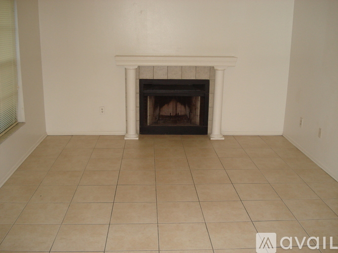 A white fireplace with a tile floor in a room.