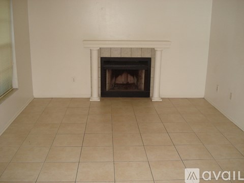 A white fireplace with a tile floor in a room.