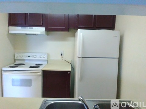A kitchen with a white refrigerator, white stove, and white oven.
