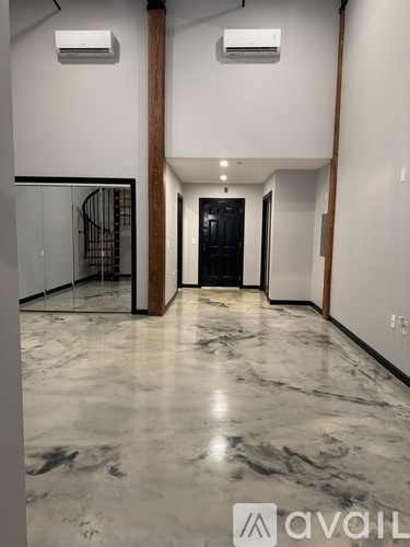 A hallway with marble flooring and two air conditioning units on the wall.