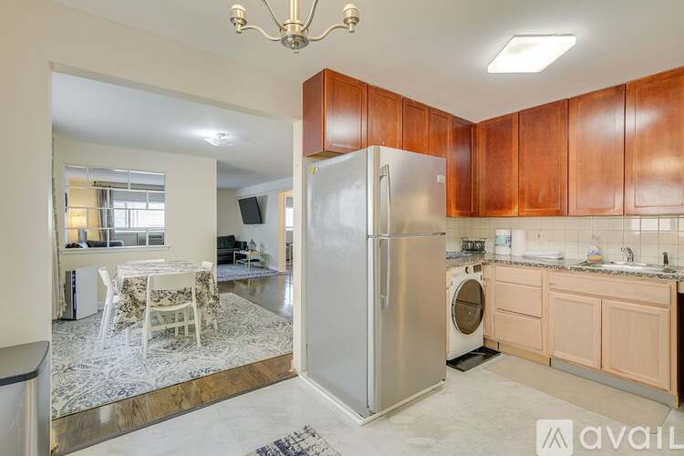 A kitchen with wooden cabinets and a stainless steel refrigerator.