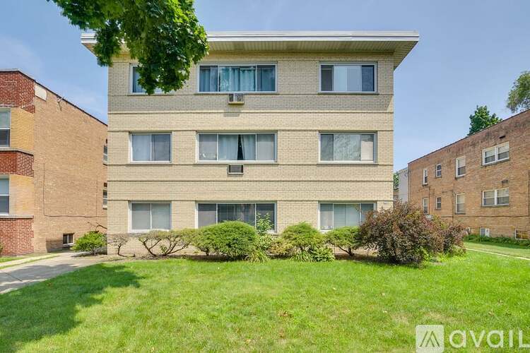A multi-story residential building with a green lawn in front.