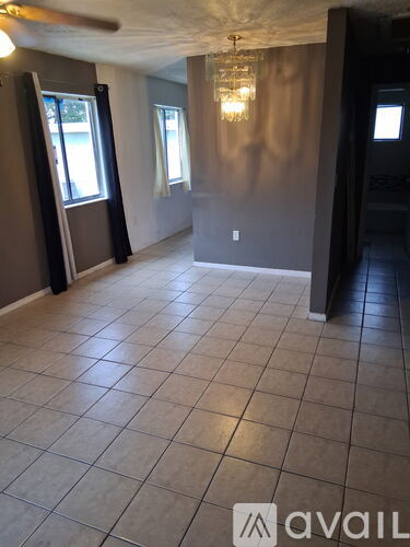 A room with tile flooring and a chandelier.