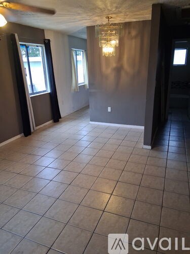A room with tile flooring and a chandelier.