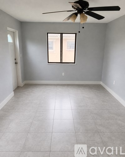 A room with a ceiling fan and a window.