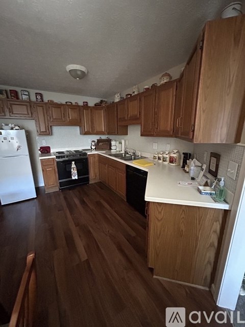 A kitchen with wooden cabinets and a white refrigerator.