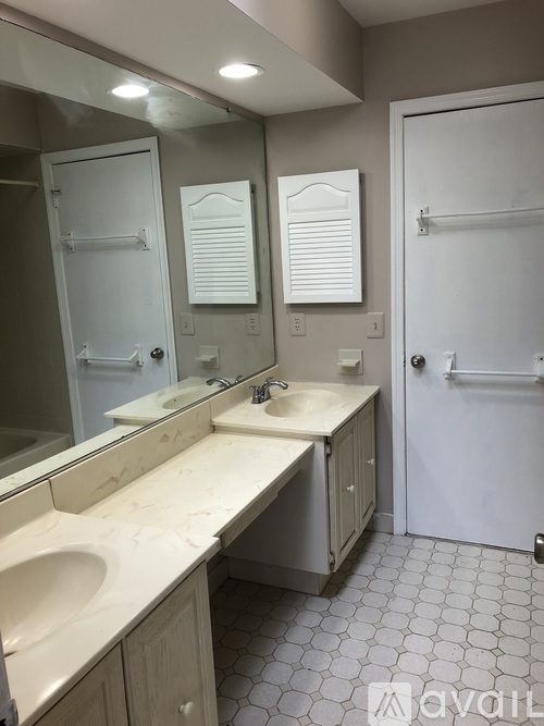 A bathroom with two sinks and a white door.