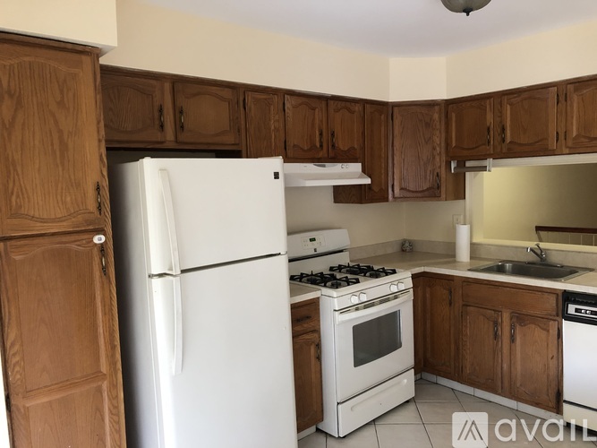 A kitchen with wooden cabinets and white appliances.