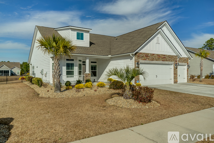 A house with a white exterior and a brown roof is for sale.