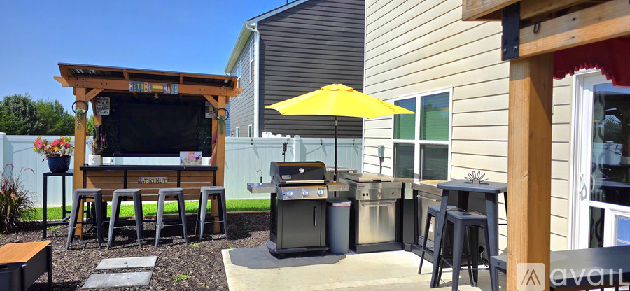 A patio with a bar and stools.