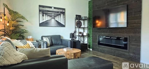 A living room with a fireplace and a television mounted above it.
