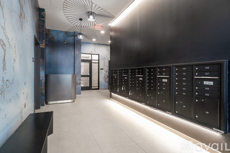 A row of black vending machines are lined up on a wall.
