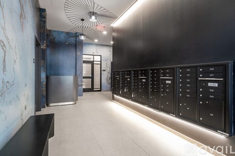 A row of black vending machines are lined up on a wall.