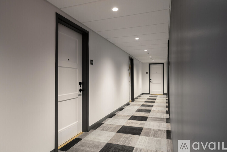A long hallway with black and white checkered flooring and white walls.