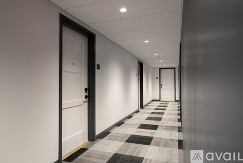 A long hallway with black and white checkered flooring and white walls.