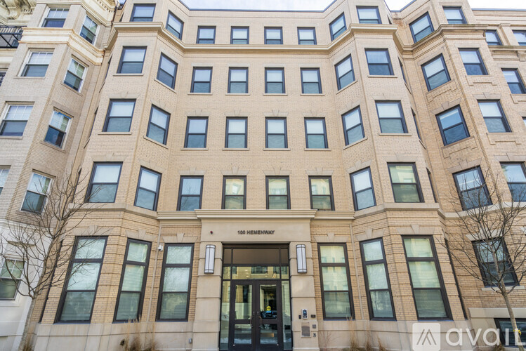 The building is a large, beige, multi-story structure with a flat roof and a central entrance.