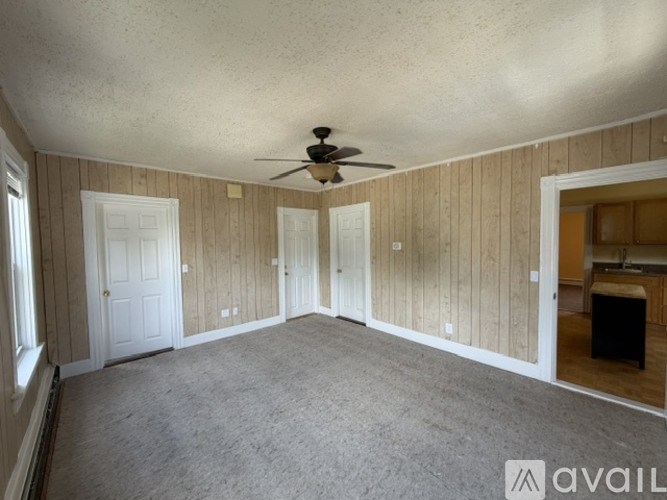 A room with wooden walls and a ceiling fan.