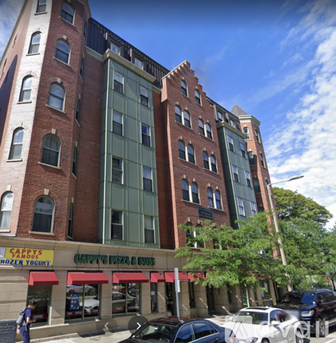 A street view of a building with a red awning that reads "Sarah's Frozen Yogurt" and "Cappy's Pizza & Brews."