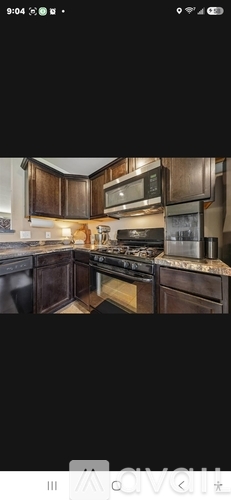 A kitchen with dark wood cabinets and a stove top oven.
